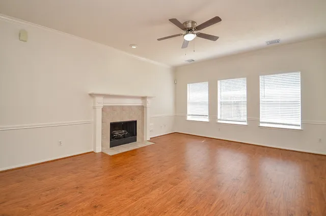 wooden floor fireplace and windows in an empty room