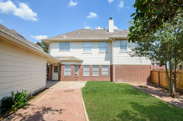 a front view of a house with a yard and potted plants