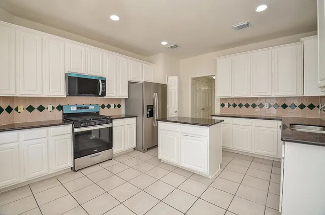 a kitchen with white cabinets a sink and white appliances