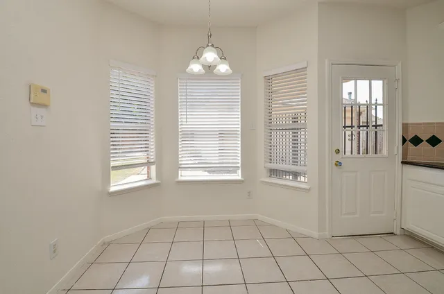 an empty room with windows and chandelier
