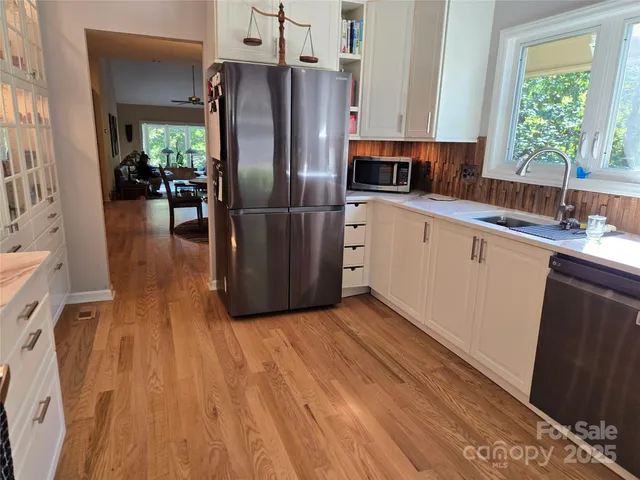 a kitchen with stainless steel appliances a refrigerator sink and cabinets