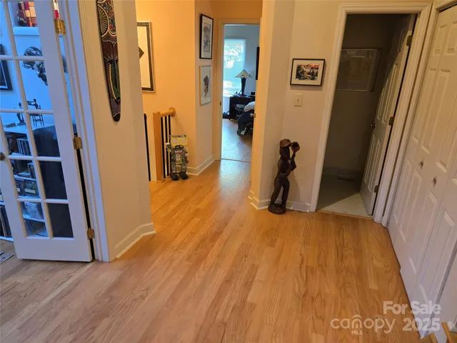 a view of a hallway with wooden floor and staircase
