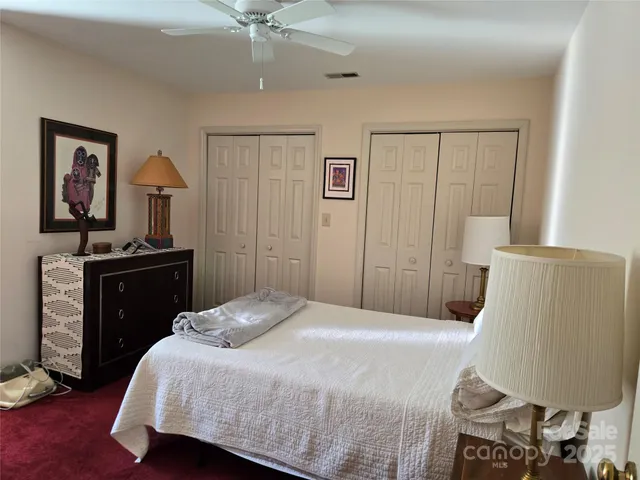 a bedroom with a bed and a lamp on dresser