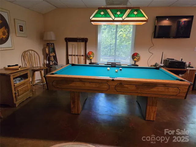 a room with pool table and windows