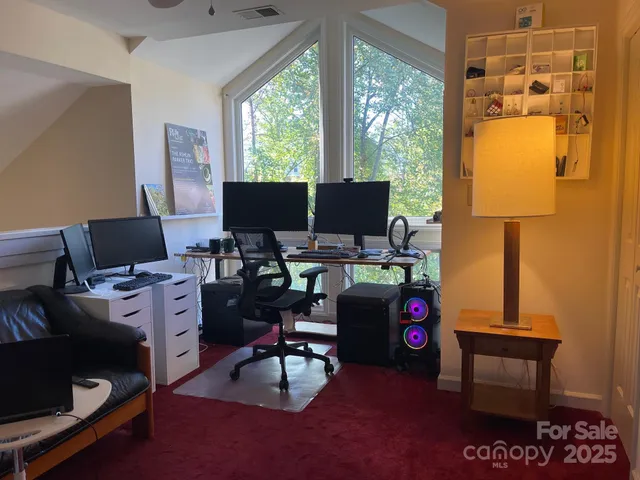 a view of a workspace with furniture and a window
