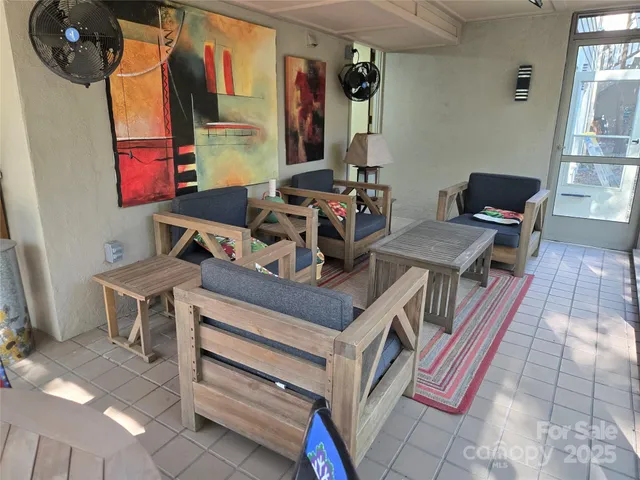 a view of a workspace with furniture and a window