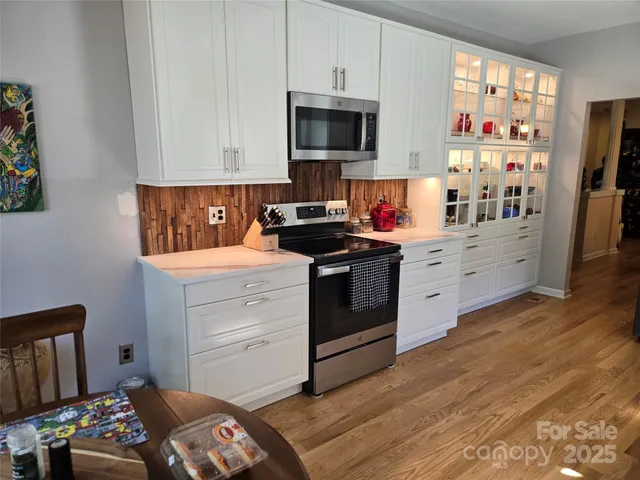 a kitchen with stainless steel appliances a stove a sink and a microwave