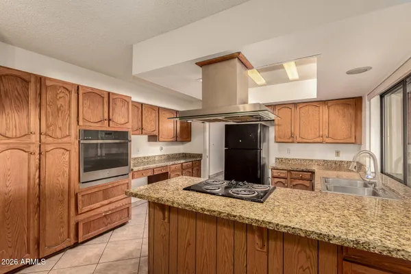 a kitchen with granite countertop stainless steel appliances and wooden cabinets