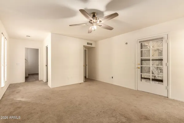 an empty room with windows and fan