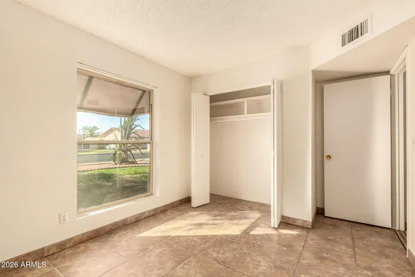a view of an empty room with glass door and a window