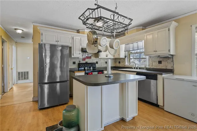 a kitchen with stainless steel appliances granite countertop a sink refrigerator and microwave