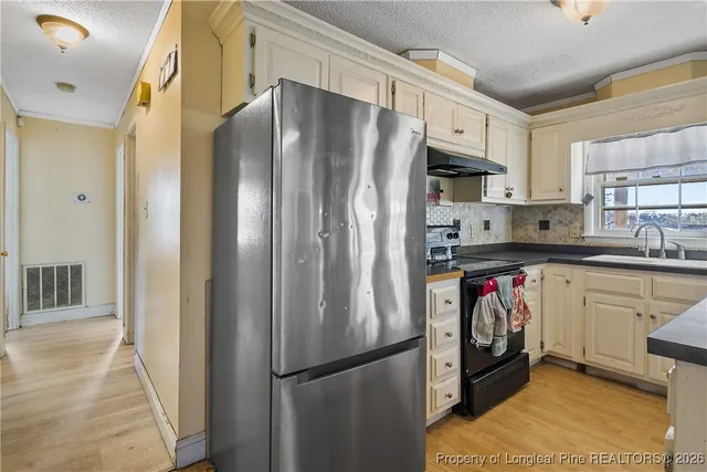 a kitchen with stainless steel appliances a refrigerator a stove a sink and a refrigerator