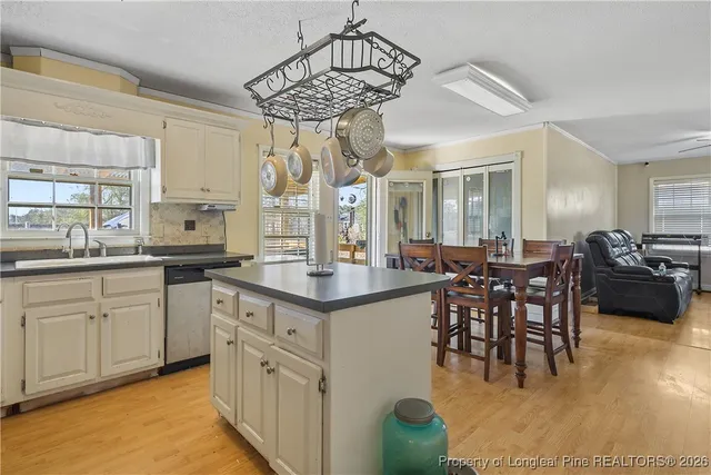 a kitchen with stainless steel appliances granite countertop a sink a stove a dining table and chairs