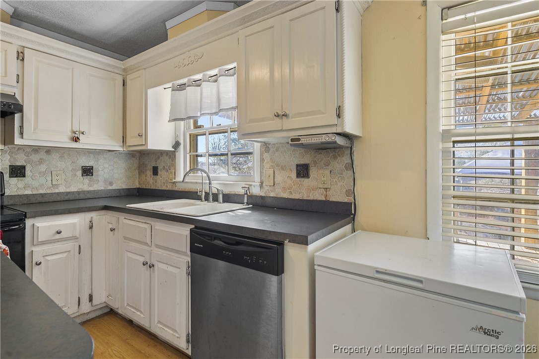 1408 Seabrook School Road Fayetteville, NC 28312 - Photo 23 of 44 a kitchen with stainless steel appliances granite countertop a sink and a white cabinets