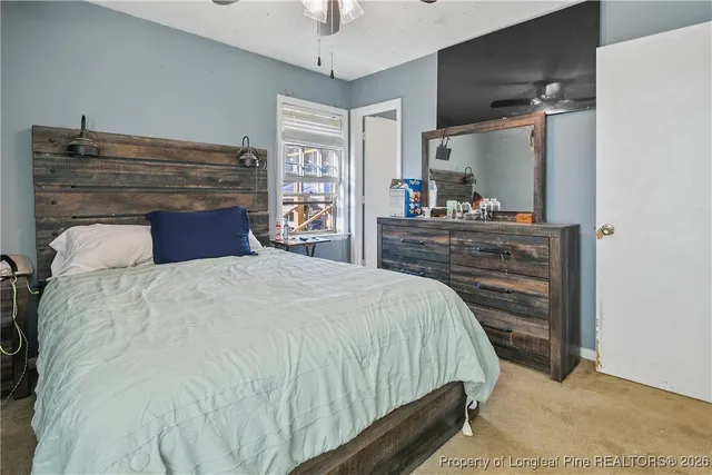 a bed sitting in a bedroom and dresser with wooden floor