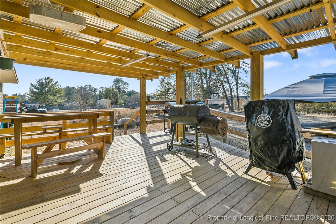 1408 Seabrook School Road Fayetteville, NC 28312 - Photo 39 of 44 a view of a patio with table and chairs and wooden floor