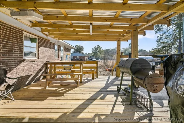 a view of a patio with table and chairs with wooden floor and fence