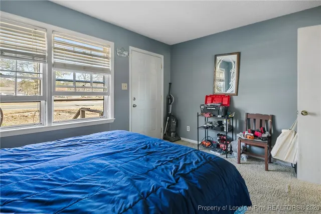 a bed sitting in a bedroom next to a window