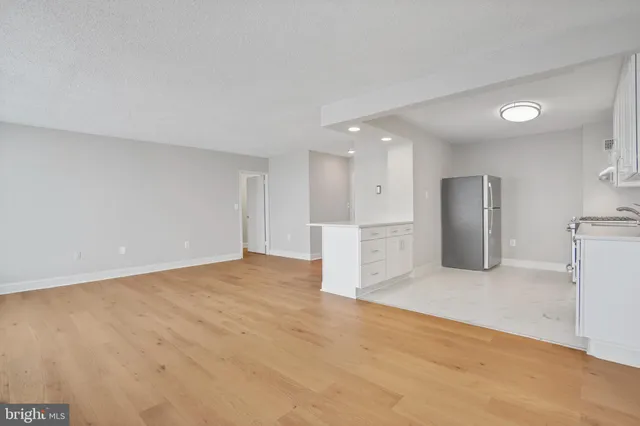 a view of an empty room with a kitchen