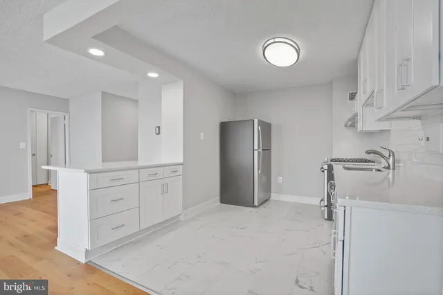 a spacious bathroom with a granite countertop sink mirror and cabinets
