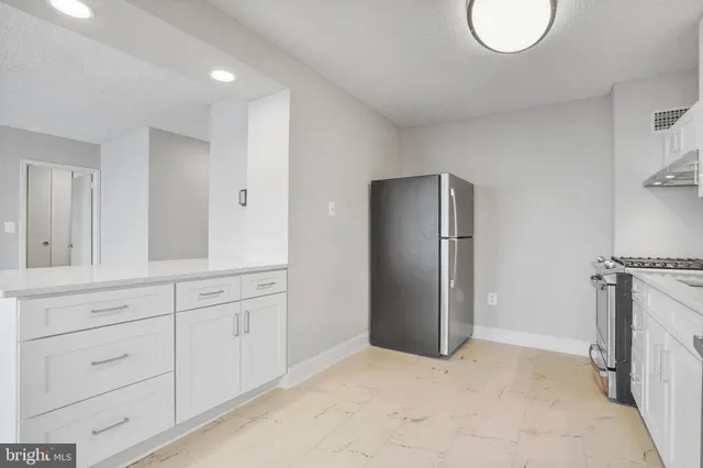 a view of a kitchen with refrigerator and window