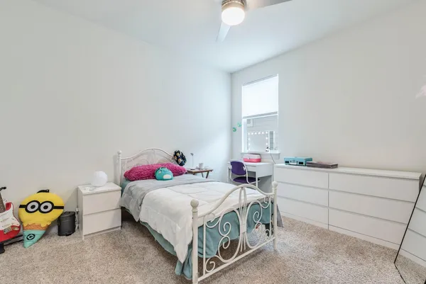 a bedroom with a bed painting on wall and windows