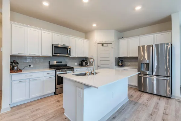 a kitchen with a sink stainless steel appliances and white cabinets