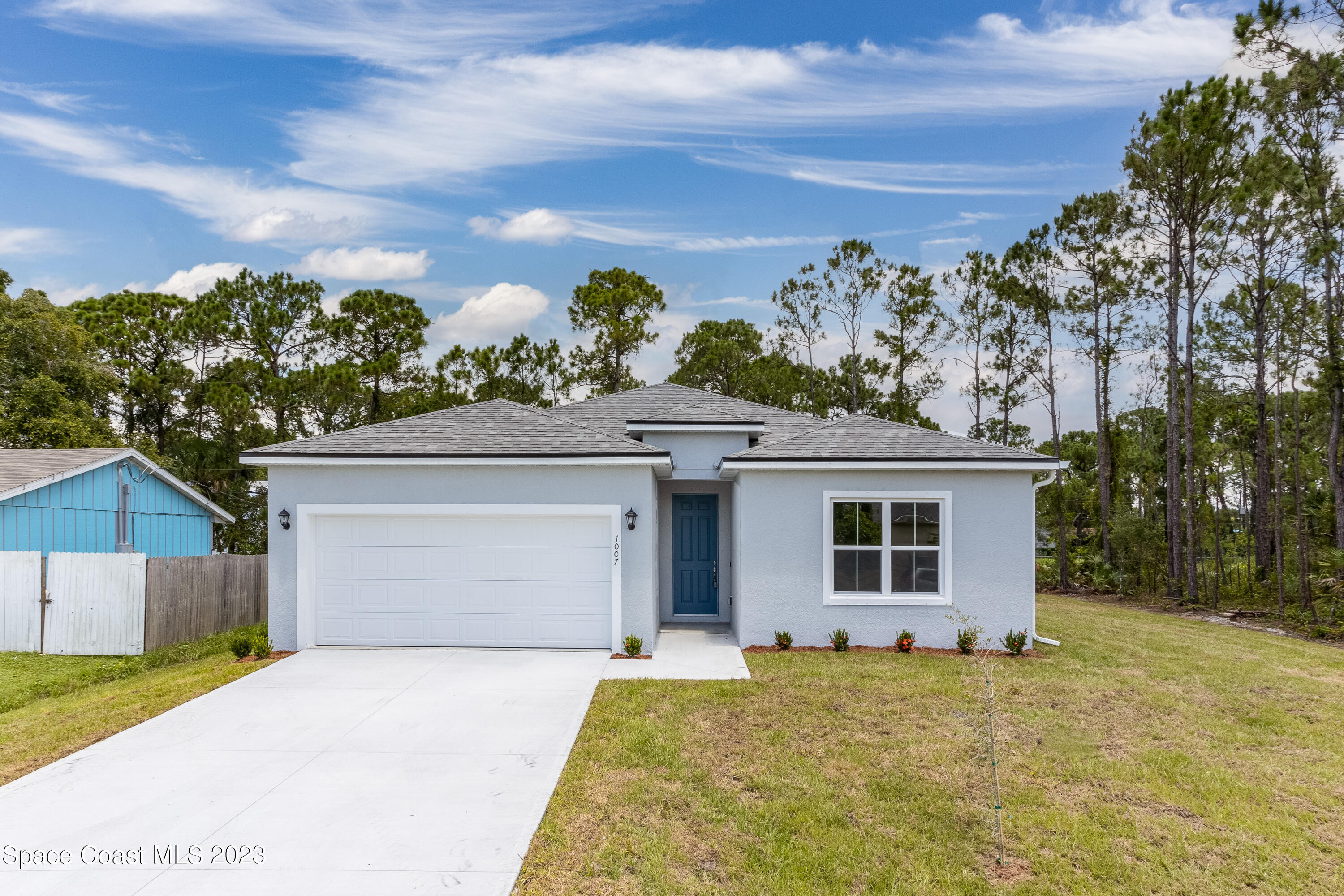 1007 San Rafael Road Southwest Palm Bay, FL 32908 - Photo 2 of 23 a front view of a house with a yard and garage