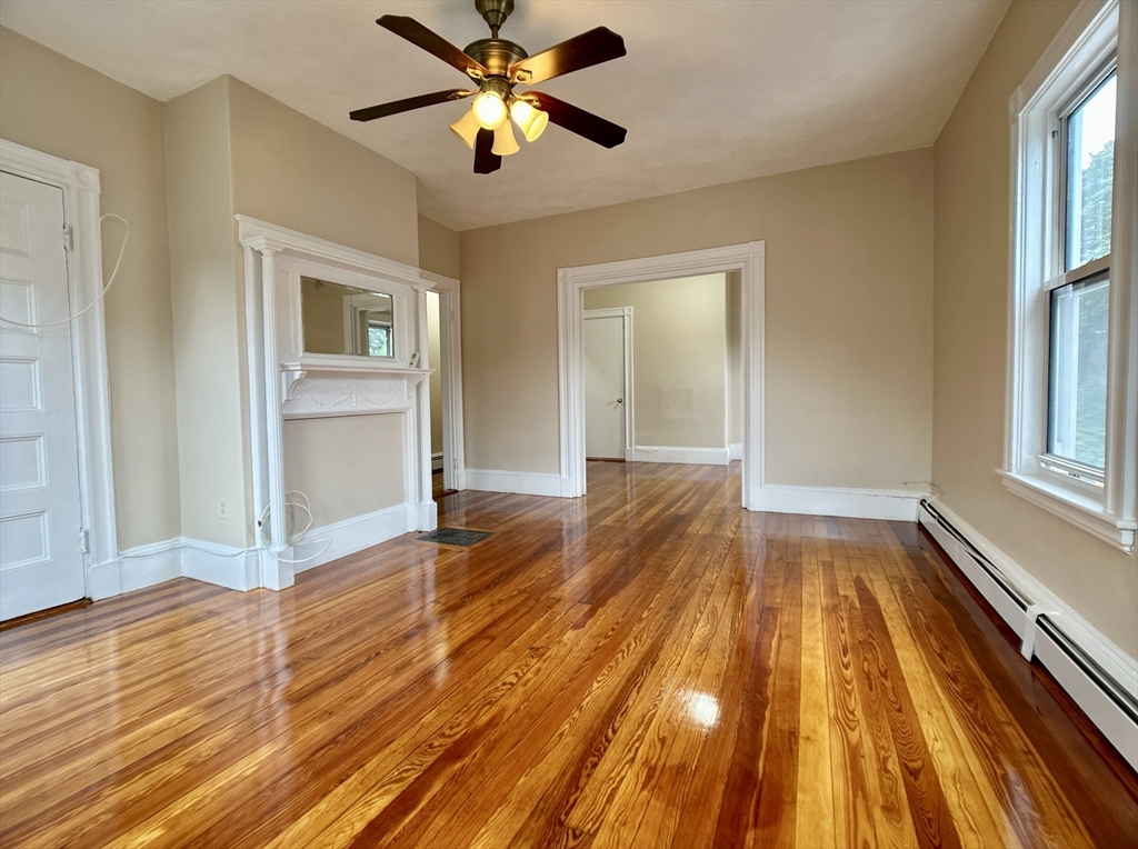 22 Spring Park Avenue, Unit 3 Boston, MA 02130 - Photo 8 of 11 wooden floor in an empty room with a window