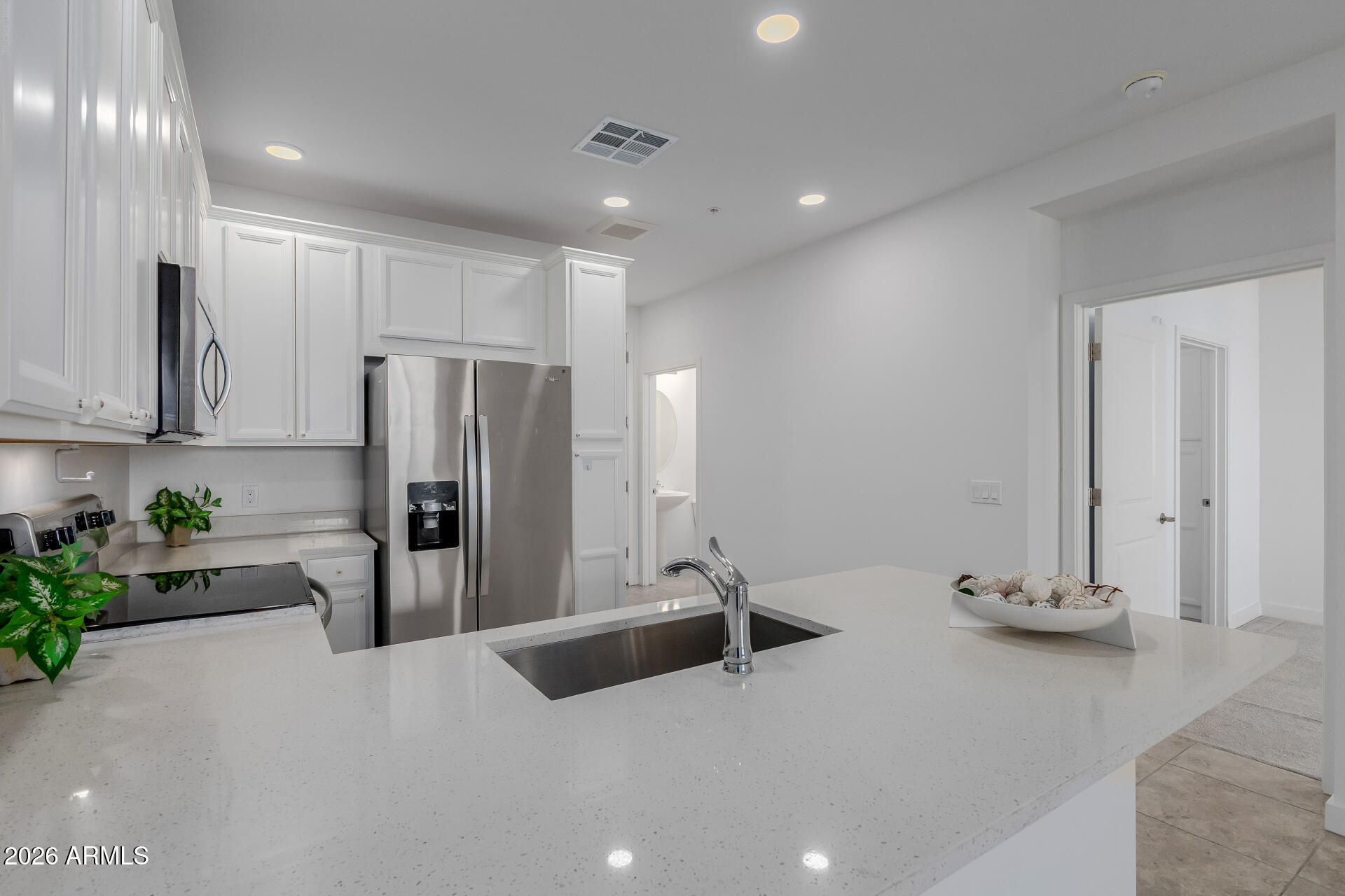 2511 West Queen Creek Road, Unit 279 Chandler, AZ 85248 - Photo 2 of 35 a kitchen with stainless steel appliances a refrigerator sink and white cabinets