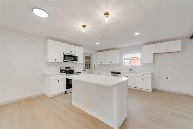 a kitchen with white cabinets and white appliances