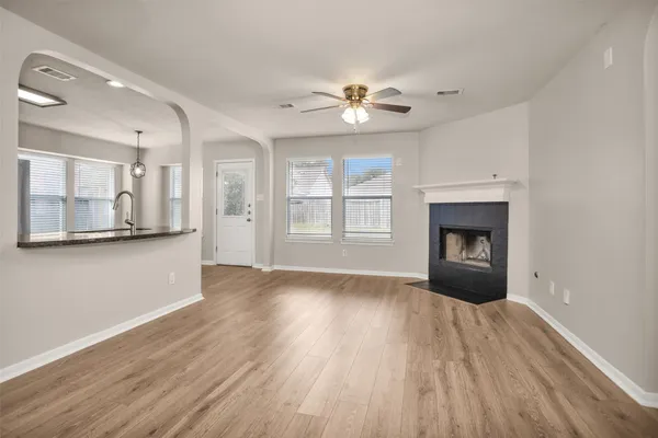 a view of an empty room with a fireplace and a window