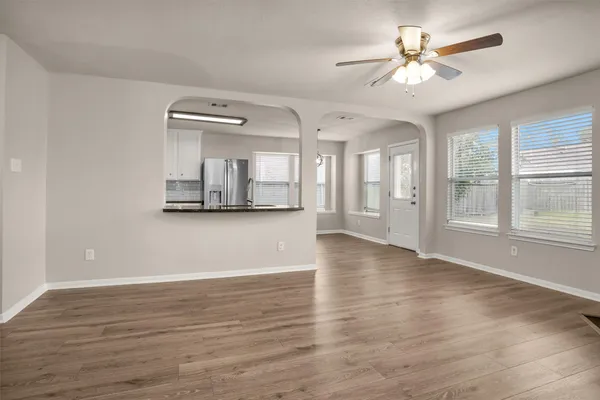 a view of an empty room with window and wooden floor