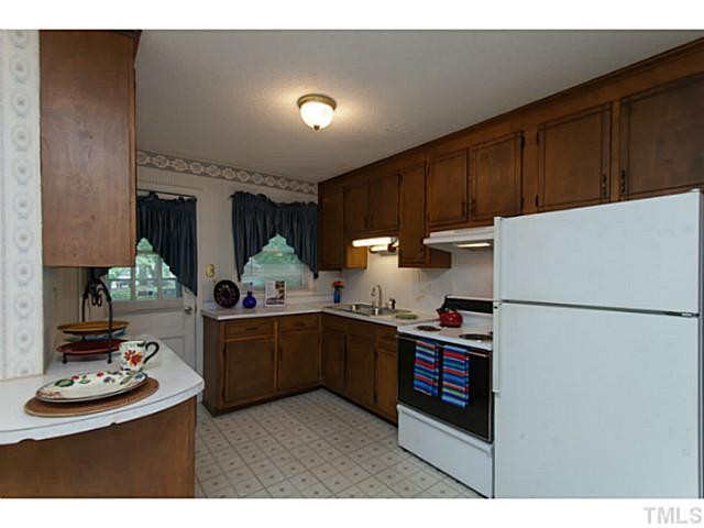 2468 Milburnie Road Raleigh, NC 27610 - Photo 6 of 25 a kitchen with refrigerator and cabinets