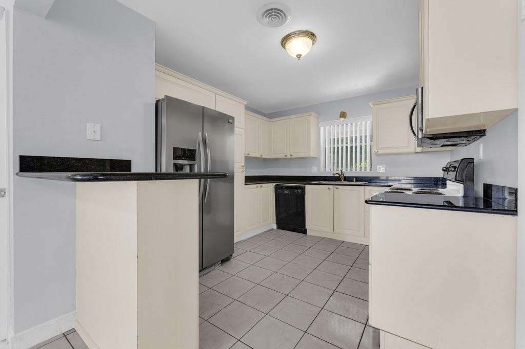 3811 Garfield Street Hollywood, FL 33021 - Photo 3 of 18 a kitchen with granite countertop a refrigerator and a sink