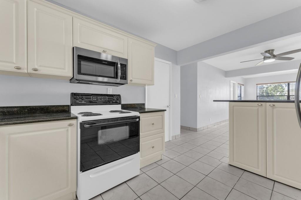 3811 Garfield Street Hollywood, FL 33021 - Photo 4 of 18 a kitchen with white cabinets and stainless steel appliances