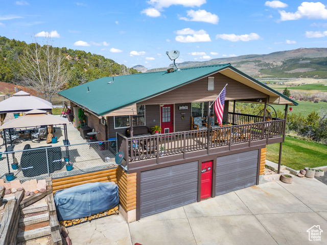 6407 North Dry Frk Cyn Road West Vernal, UT 84078 - Photo 4 of 48 View of front of home with concrete driveway, an attached garage, a gazebo, and a mountain view