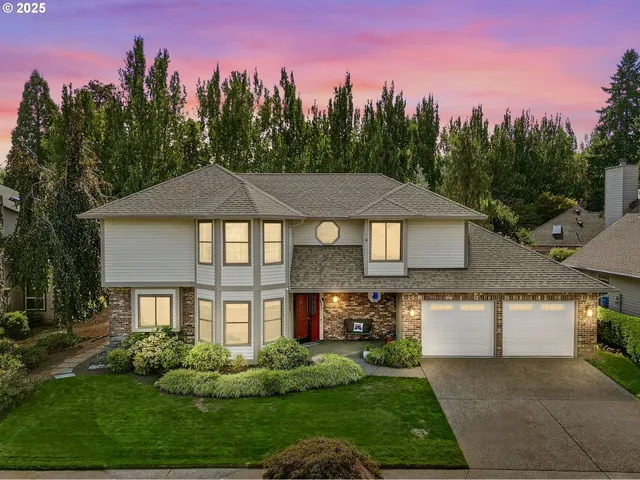 a front view of a house with a yard and trees