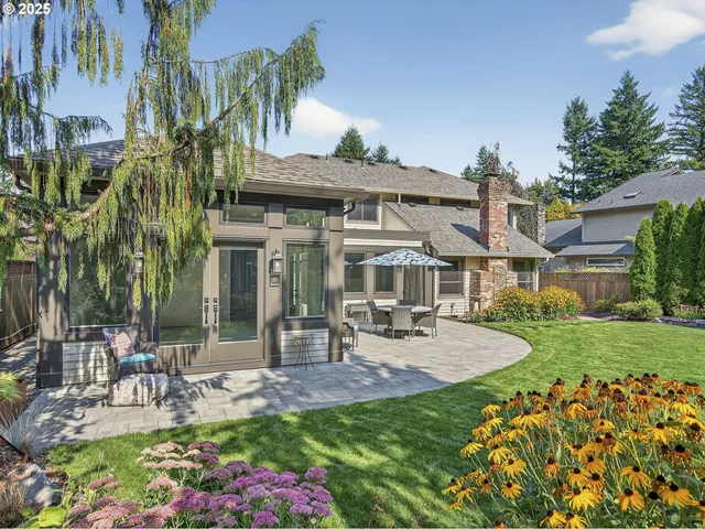 a view of a patio with table and chairs potted plants and palm tree