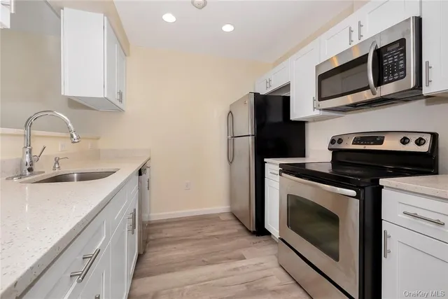 a kitchen with stainless steel appliances a stove microwave and sink