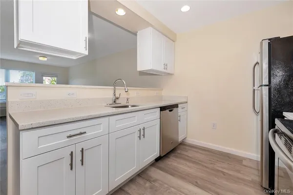 a kitchen with white cabinets stainless steel appliances and sink