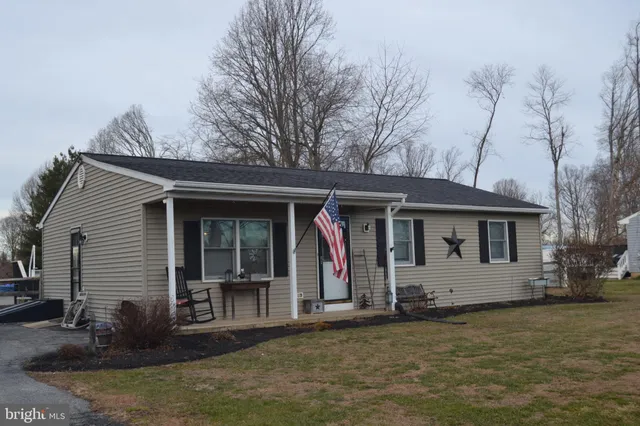 a view of a house with wooden walls and a yard