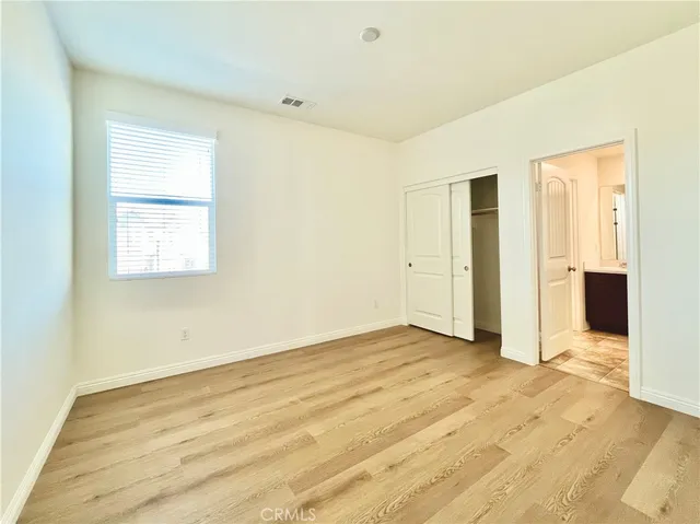 an empty room with wooden floor and closet