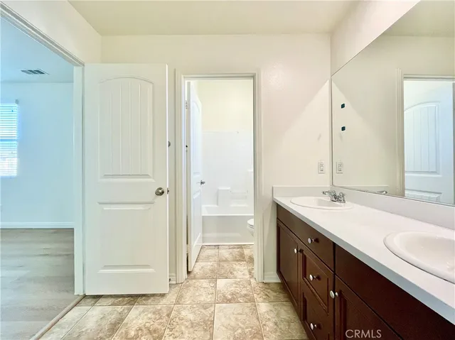 a white toilet and tub sitting next to a bathroom sink