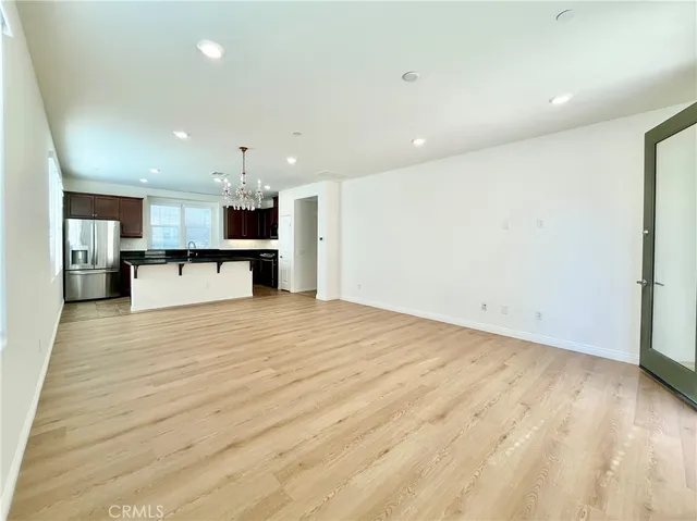 a view of a kitchen with kitchen island a sink wooden floor and a counter top space