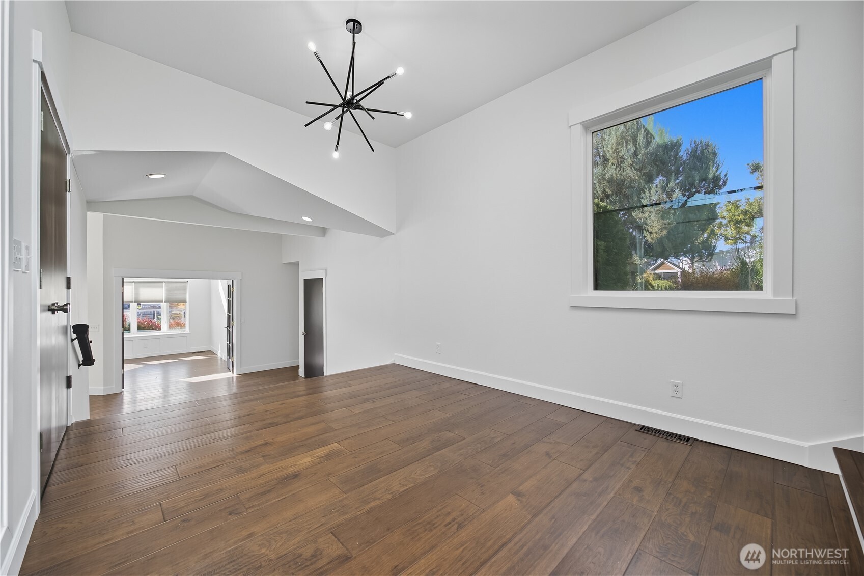 5404 Collins Road West Richland, WA 99353 - Photo 4 of 39 a view of an empty room with wooden floor and a painting on the wall