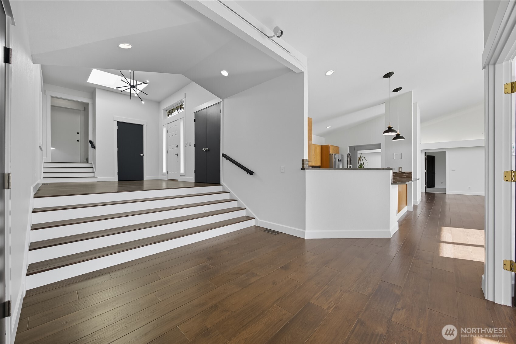 5404 Collins Road West Richland, WA 99353 - Photo 5 of 39 a view of a living room and kitchen with furniture wooden floor and a chandelier
