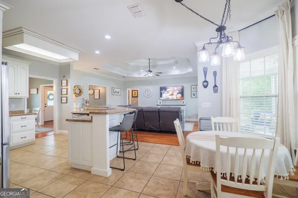 a living room with furniture a table and kitchen view