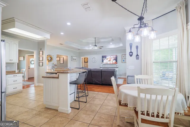 a living room with furniture a table and kitchen view