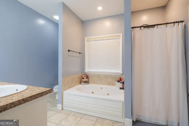 a bathroom with a granite countertop sink and a bathtub